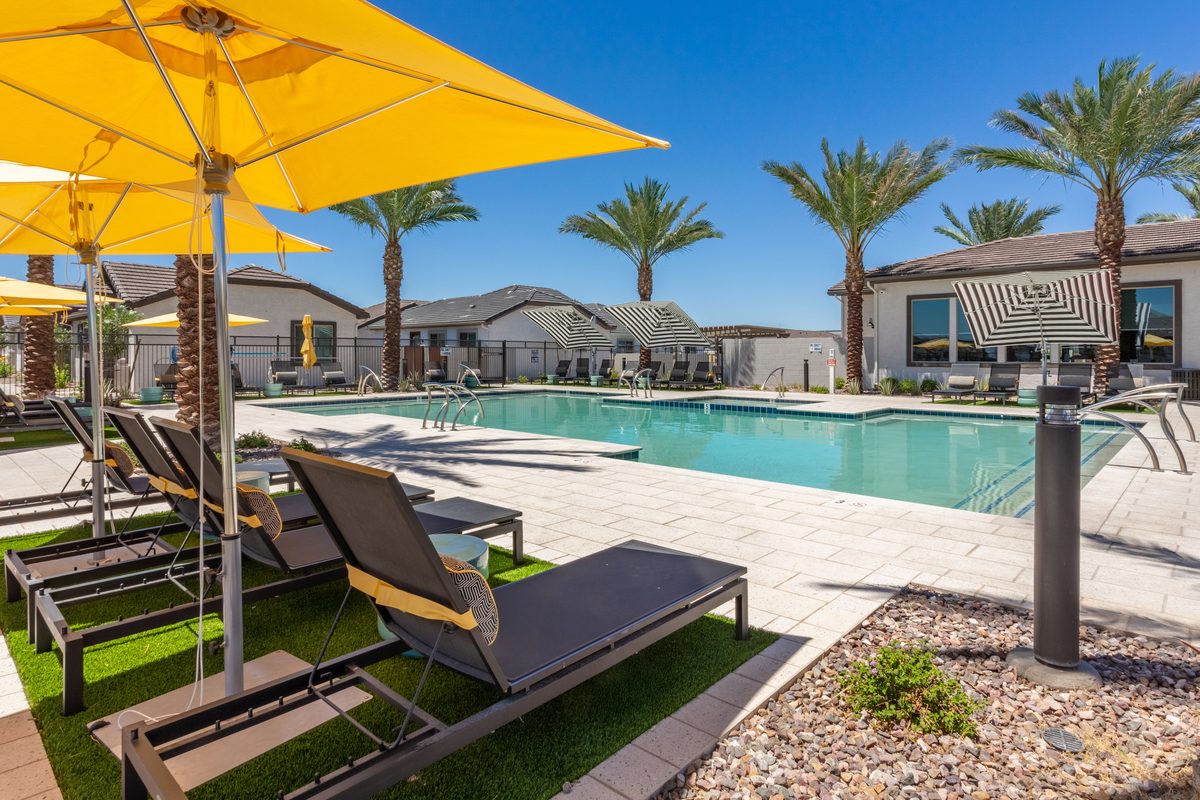 Pool deck with yellow umbrellas and single-storey rental homes at a Stellar build-to-rent community