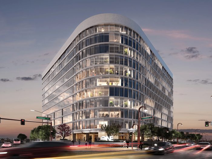 One Camelback, a curved glass tower at Central and Camelback in Phoenix, lit at dusk