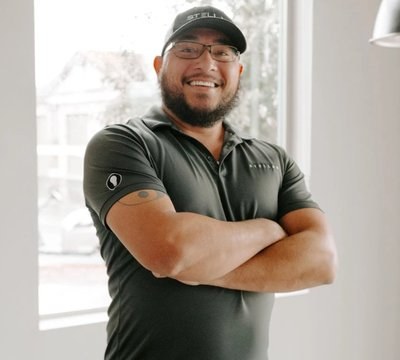 A Stellar maintenance manager in a branded polo and cap at a community office